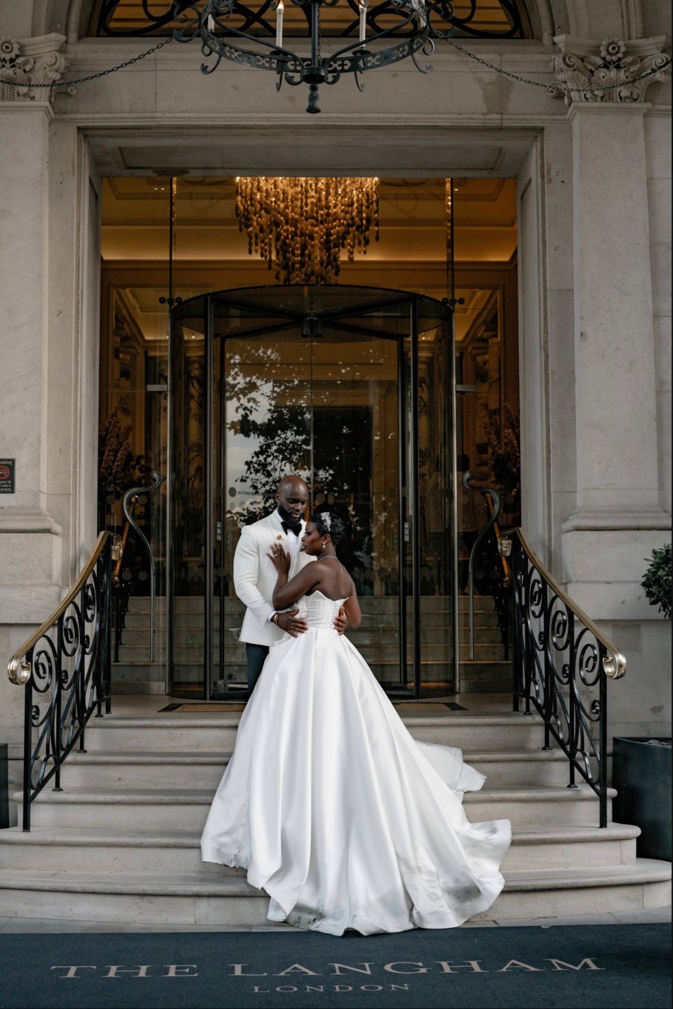 A bride and groom on the steps of a London hotel, England
