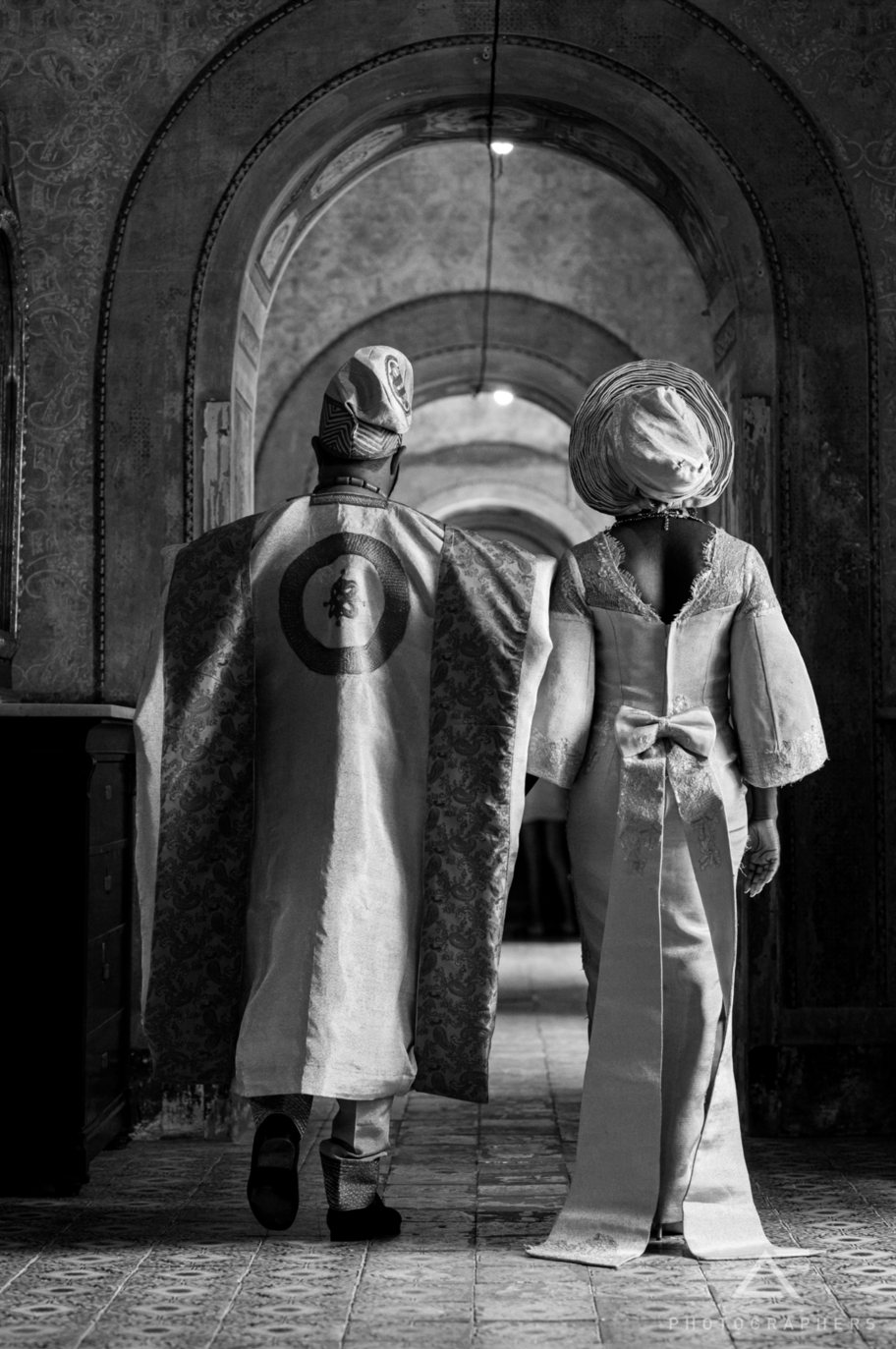 Tobi & Nick walking through a vaulted corridor in Palermo, Sicily, in black and white