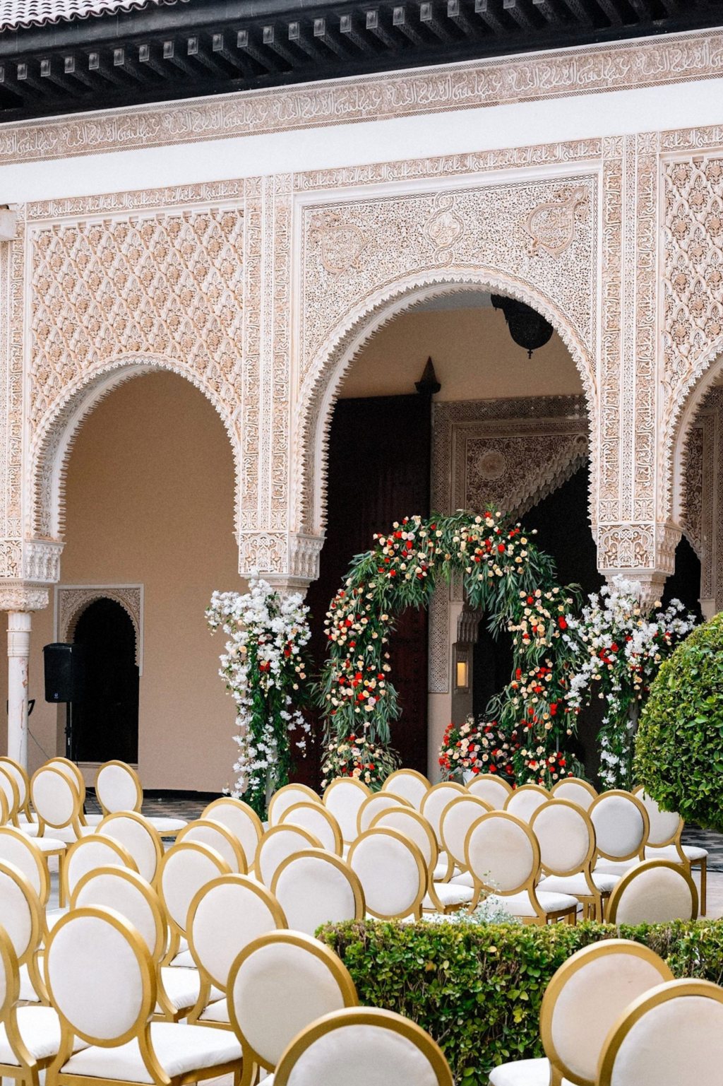 A wedding ceremony courtyard with gold chairs and carved arches in Marrakech, Morocco